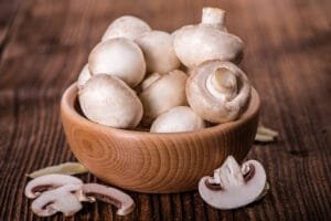 Champignons de Paris sales qui vont être nettoyés