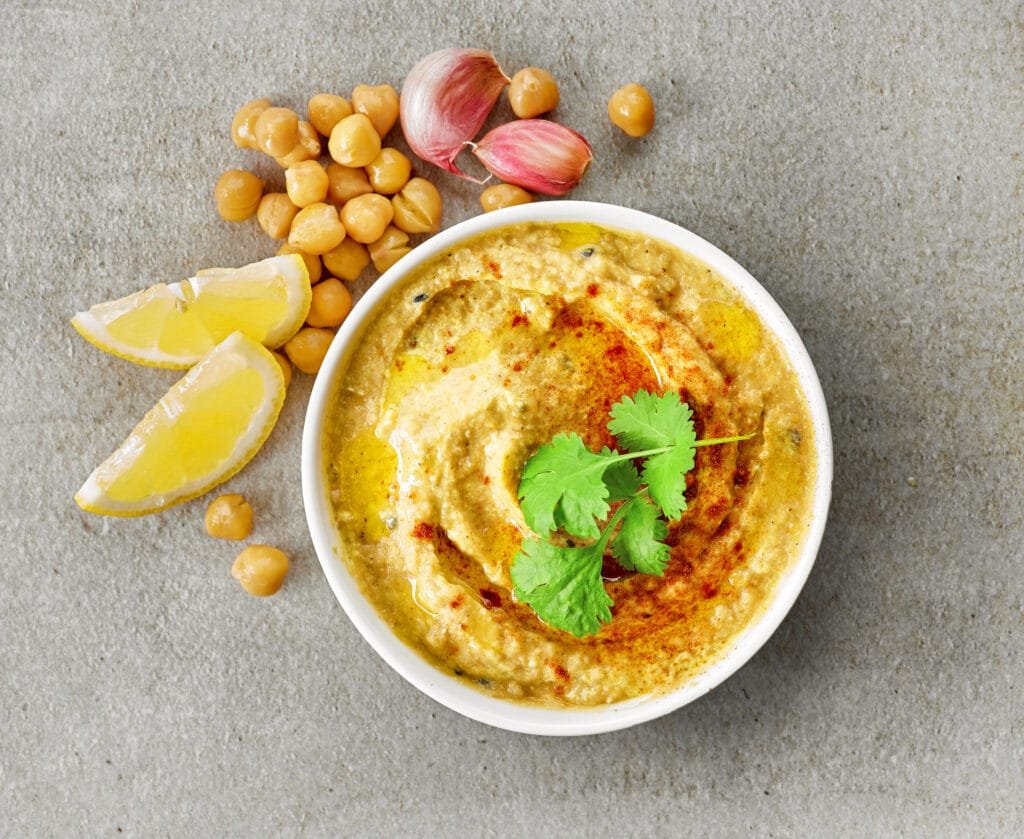 Recette houmous libanais, bol garni d'huile d'olive, de paprika et de coriande