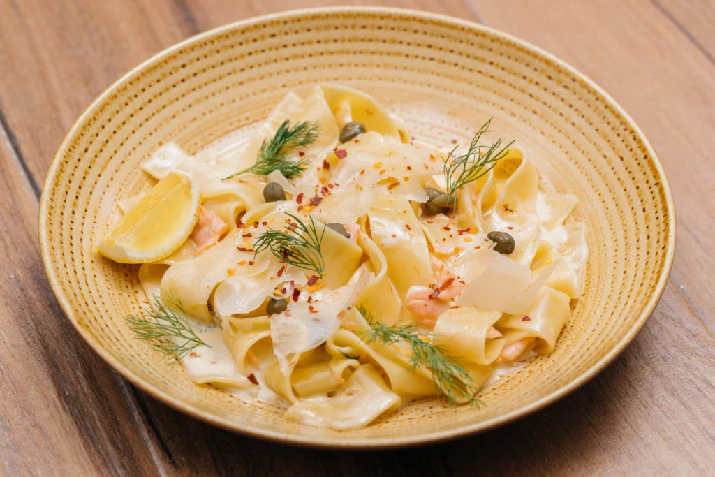 Assiette de pappardelle au saumon frais avec câpres, citron, copeaux de parmesan et aneth