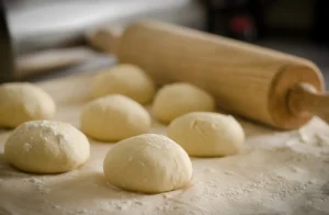 Boules de pâte à pizza maison pour illustrer la préparation d’une pâte à pizza maison traditionnelle italienne moelleuse et croustillante avec des ingrédients simples