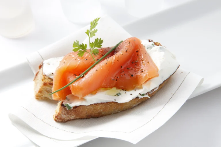 Tranches de saumon fumé disposées sur un toast avec du fromage frais, illustrant la congélation du saumon fumé.