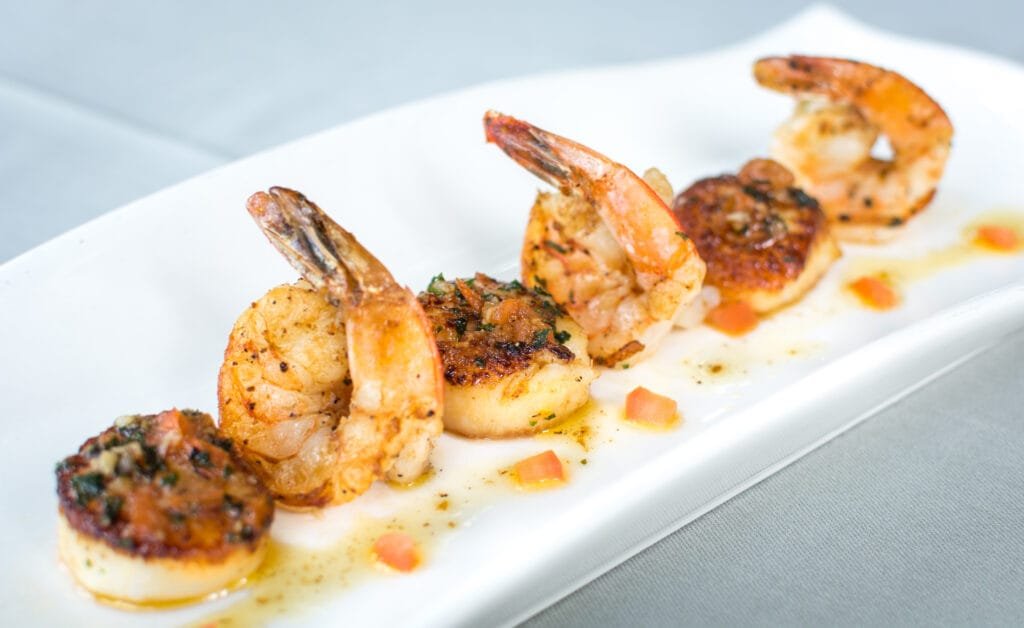 Assiette gourmande de Saint-Jacques et crevettes poêlées et parsemées de persil