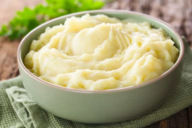 Photo d'une purée de pommes de terre maison crémeuse servie avec une noisette de beurre fondant
