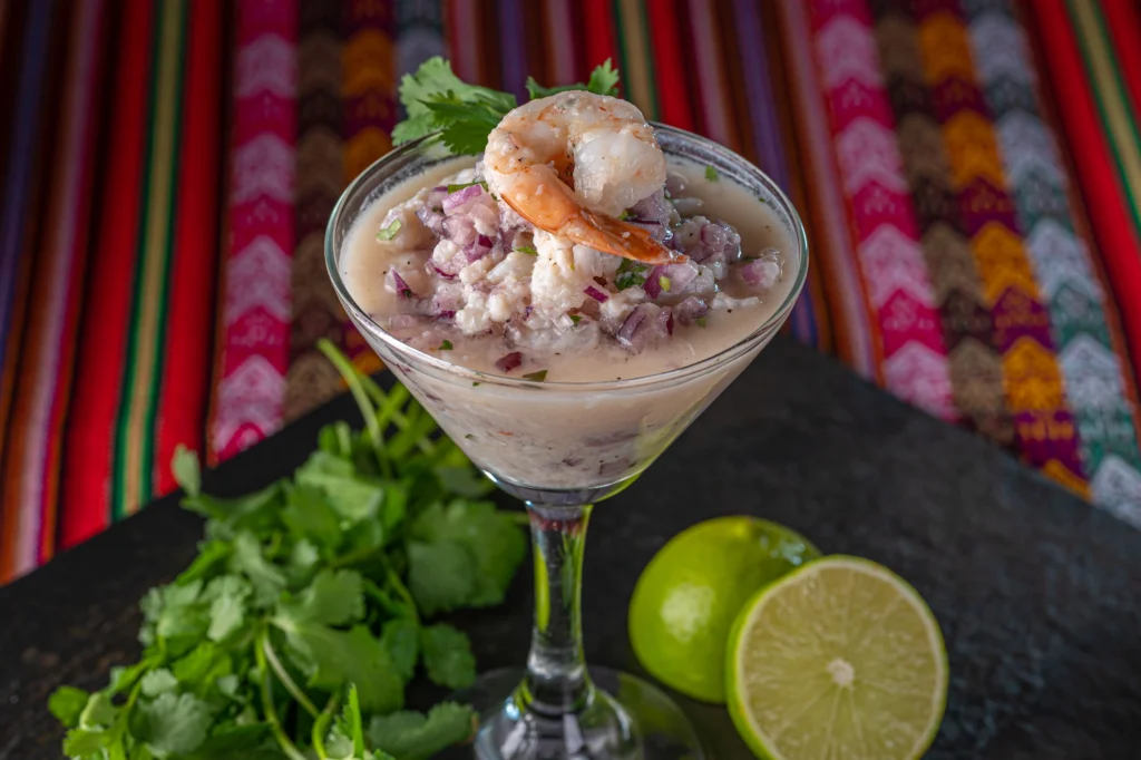 Ceviche leche de tigre crémeux avec crevette, oignon rouge et coriandre dans un verre