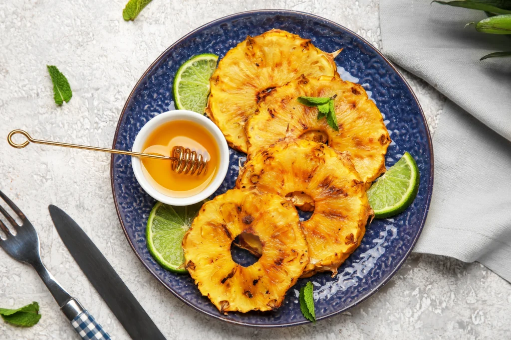 Ananas rôti caramélisé au miel, zestes de citron vert et feuilles de menthe fraîche