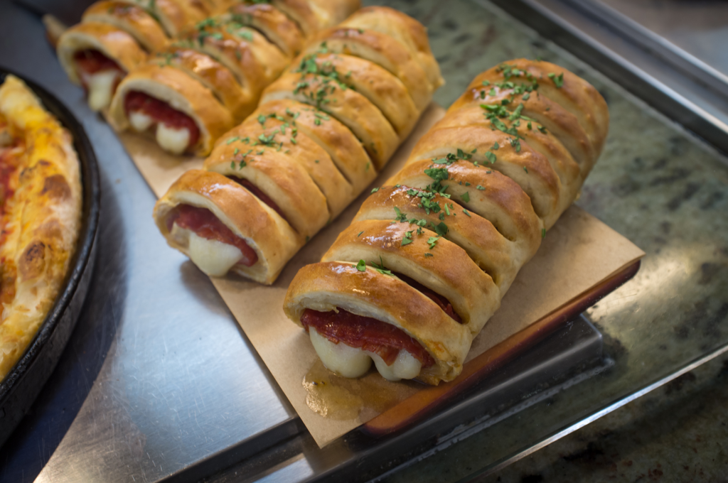Bouchées de stromboli garnies de mozzarella fondue et salami, dorées au four