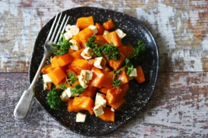 Salade de potimarron rôti avec des morceaux de feta, du persil et un filet de vinaigre balsamique