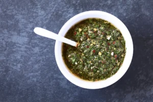 Pot de sauce chimichurri maison avec herbes fraîches et huile d’olive