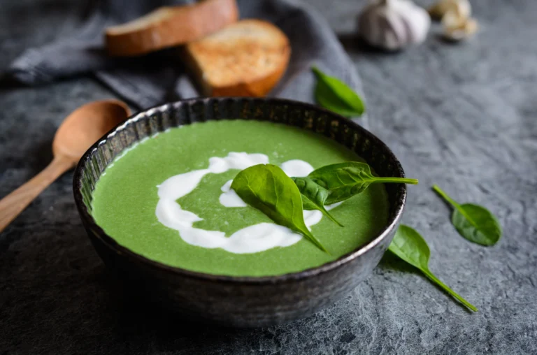 Bol de soupe d’épinards à la crème avec croûtons et crème fraîche