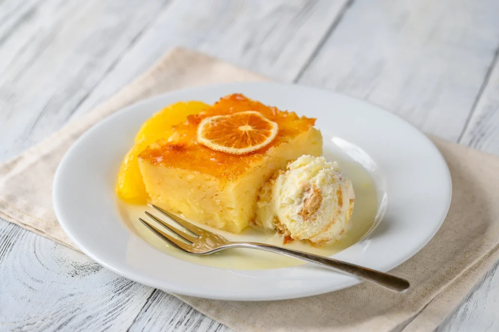 Gâteau grec Portokalopita à l’orange, nappé de sirop et décoré de tranches d’orange avec une boule de glace en accompagnement