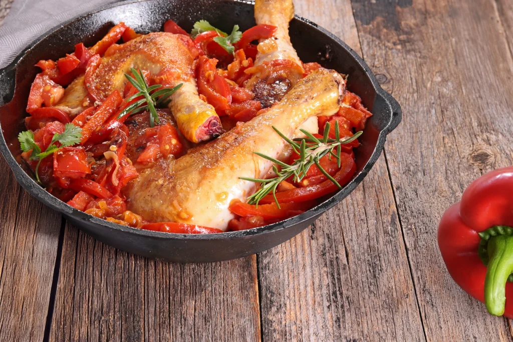 Poulet basquaise mijoté traditionnel avec poivrons, sauce tomate maison, plat rustique du Pays Basque