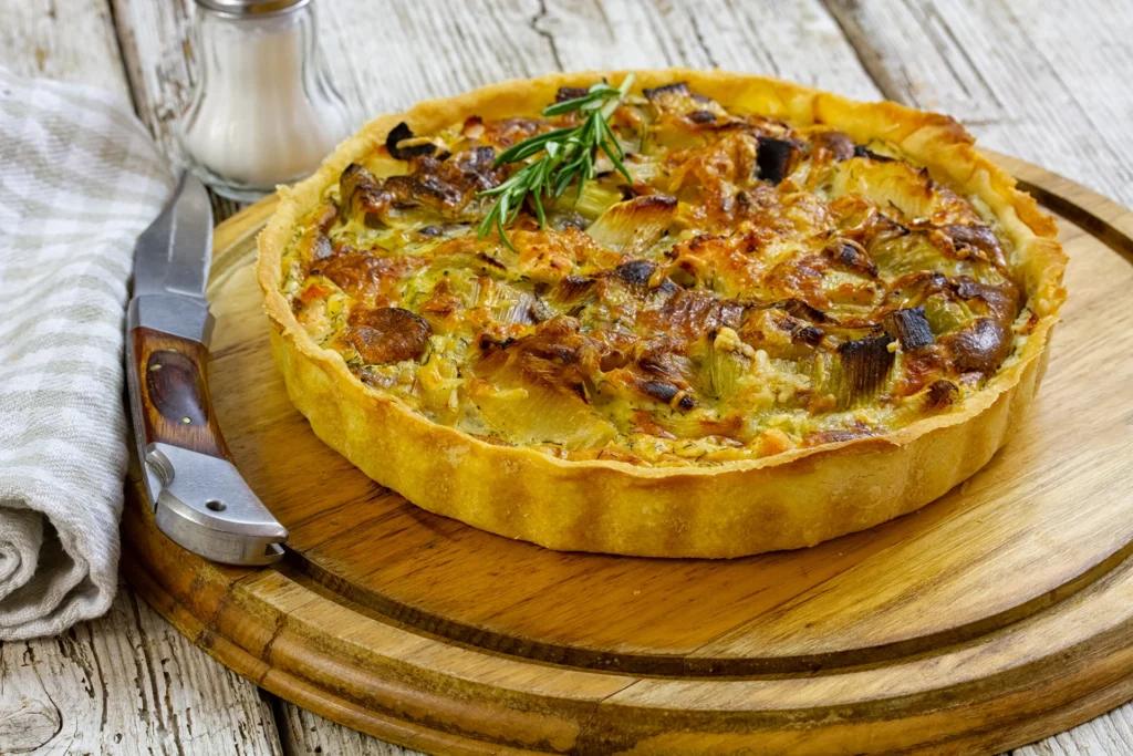 Tarte aux poireaux maison sur une planche en bois