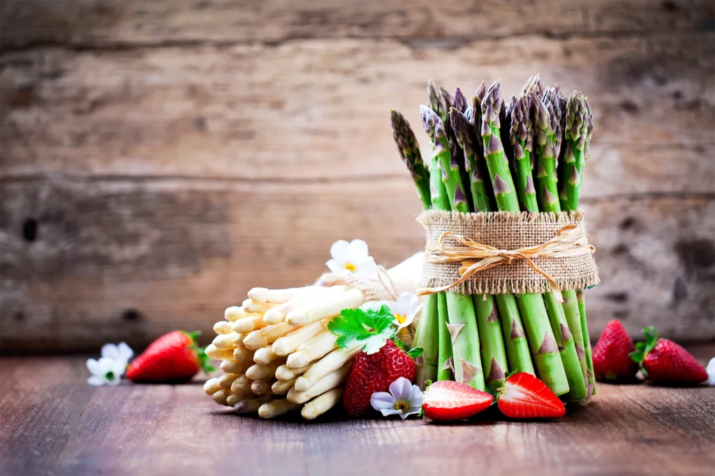 Botte d’asperges vertes avec asperges blanches et fraises fraîches, symboles des recettes de printemps