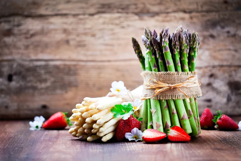 Botte d’asperges vertes avec asperges blanches et fraises fraîches, symboles des recettes de printemps