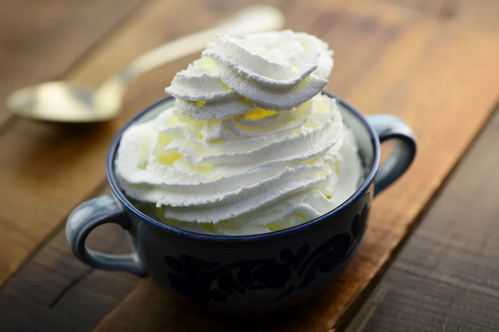 Crème chantilly maison légère et ferme servie dans une tasse bleue rustique