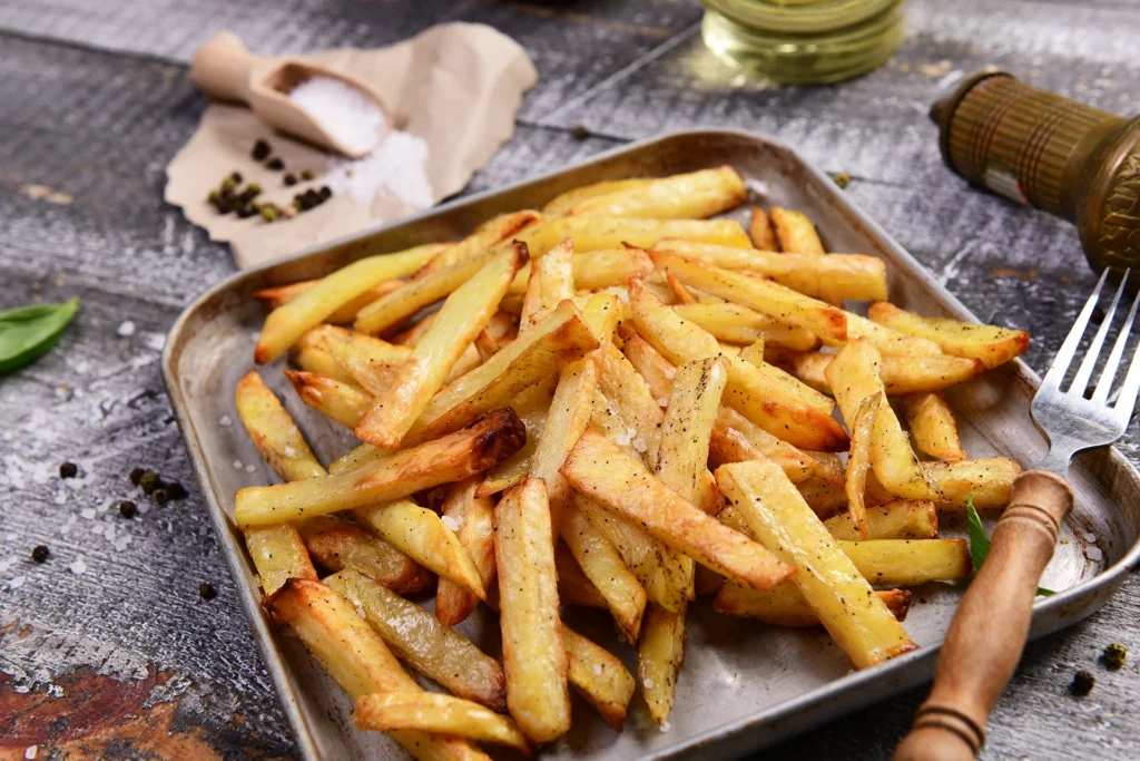 Photo de frites au four maison, dorées et croustillantes, servies dans un plateau
