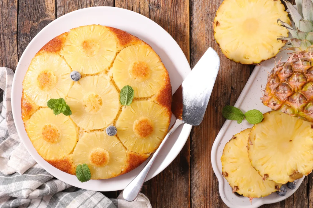 Photo d’un gâteau renversé à l’ananas caramélisé, décoré de myrtilles fraîches et de feuilles de menthe