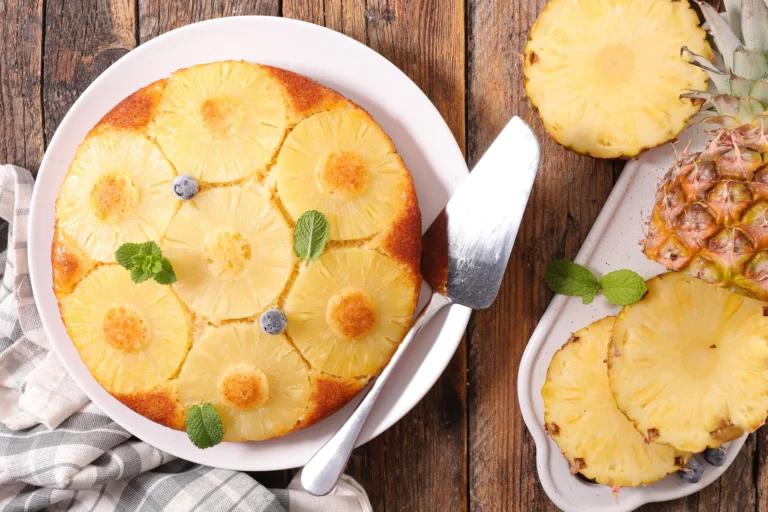 Photo d’un gâteau renversé à l’ananas caramélisé, décoré de myrtilles fraîches et de feuilles de menthe