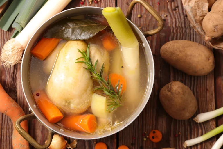 Recette de poule au pot traditionnelle servie avec carottes, navets, poireaux poireaux et pommes de terre