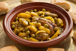 Tajine de poulet marocain aux olives, pommes de terre et citron confit dans un plat traditionnel en terre cuite