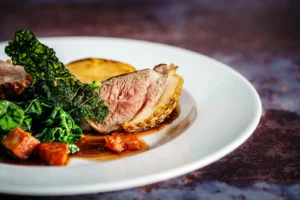 Magret de canard rosé servi avec galette de pommes de terre, légumes verts et sauce – idées d’accompagnements