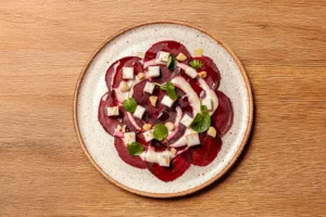 Entrée fraîche de carpaccio de betterave et poire avec sauce au yaourt