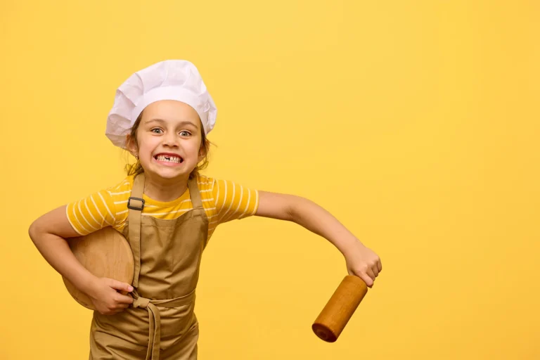 Petite fille en toque et tablier prête à cuisiner, idée ludique pour illustrer des recettes à faire avec les enfants