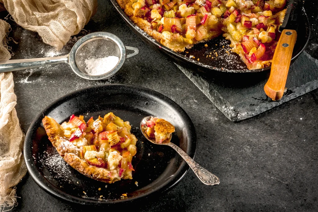 Part de tarte à la rhubarbe maison avec pâte brisée croustillante et sucre glace saupoudré