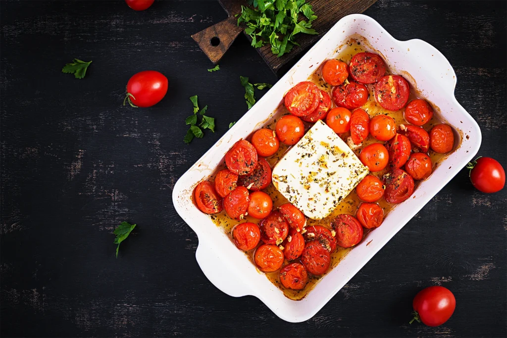 Plat de tomates cerises rôties au four avec un bloc de feta fondante