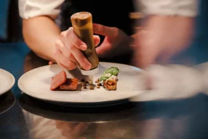 Chef réalisant le dressage d’un plat gastronomique lors d’un cours de cuisine