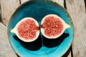 Deux moitiés de figue fraîche mûre dans une assiette, illustrant les bienfaits des figues fraîches
