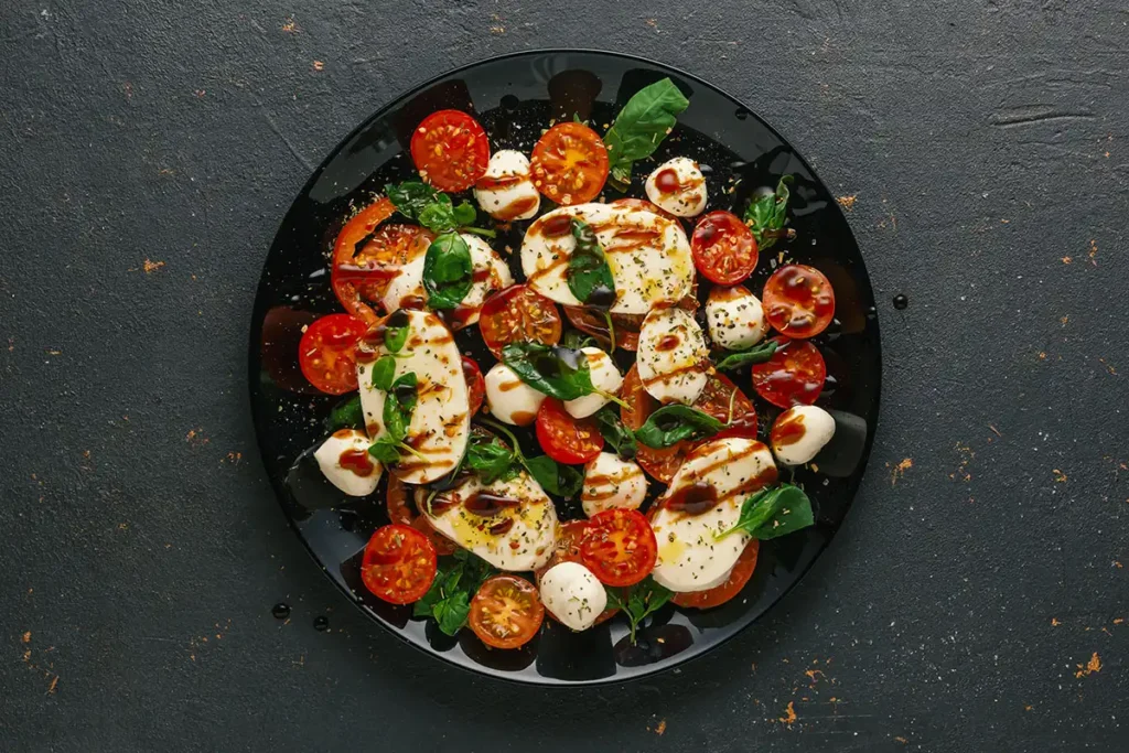 Assiette de salade Caprese traditionnelle avec mozzarella, tomates fraîches, basilic et filet de balsamique