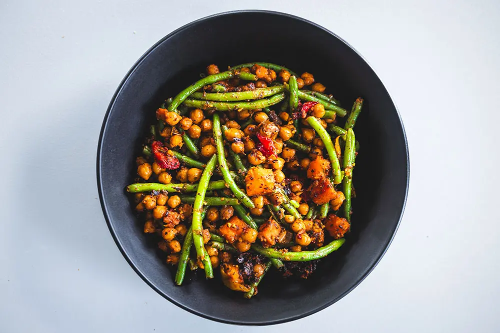 Salade tiède de pois chiches et haricots verts aux épices, courge rôtie et tomates séchées