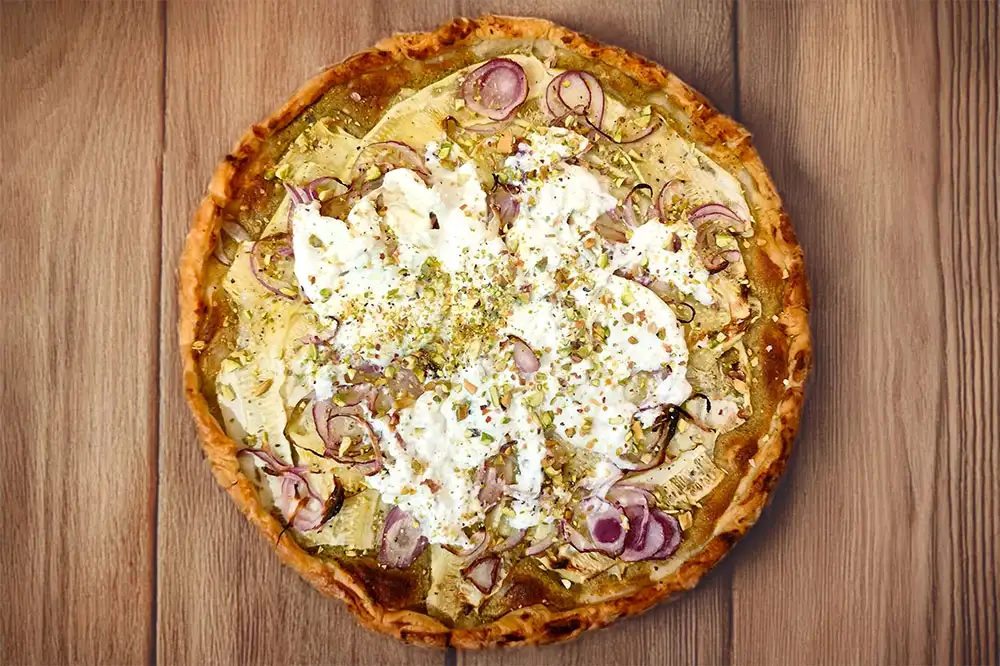 Tarte salée aux courgettes et oignons rouges, crème de pesto au basilic, burrata et pistaches