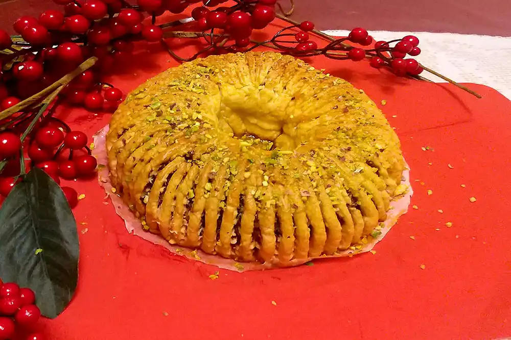 Buccellato sicilien, couronne sablée dorée garnie de figues, fruits confits et amandes, dessert traditionnel de Noël en Sicile.