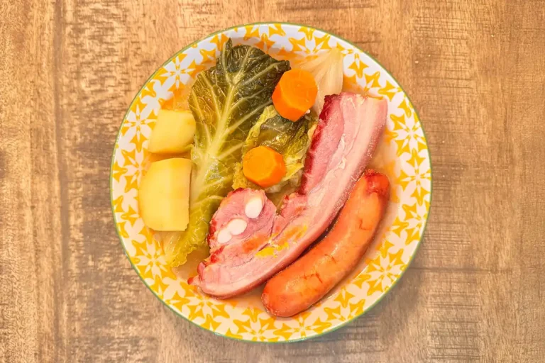 Assiette de potée au chou traditionnelle avec carottes, pommes de terre, chou vert, poitrine fumée et saucisse