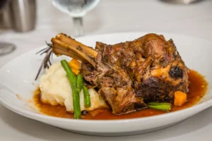 Recette de souris d’agneau confite au four servie avec purée de pommes de terre et légumes