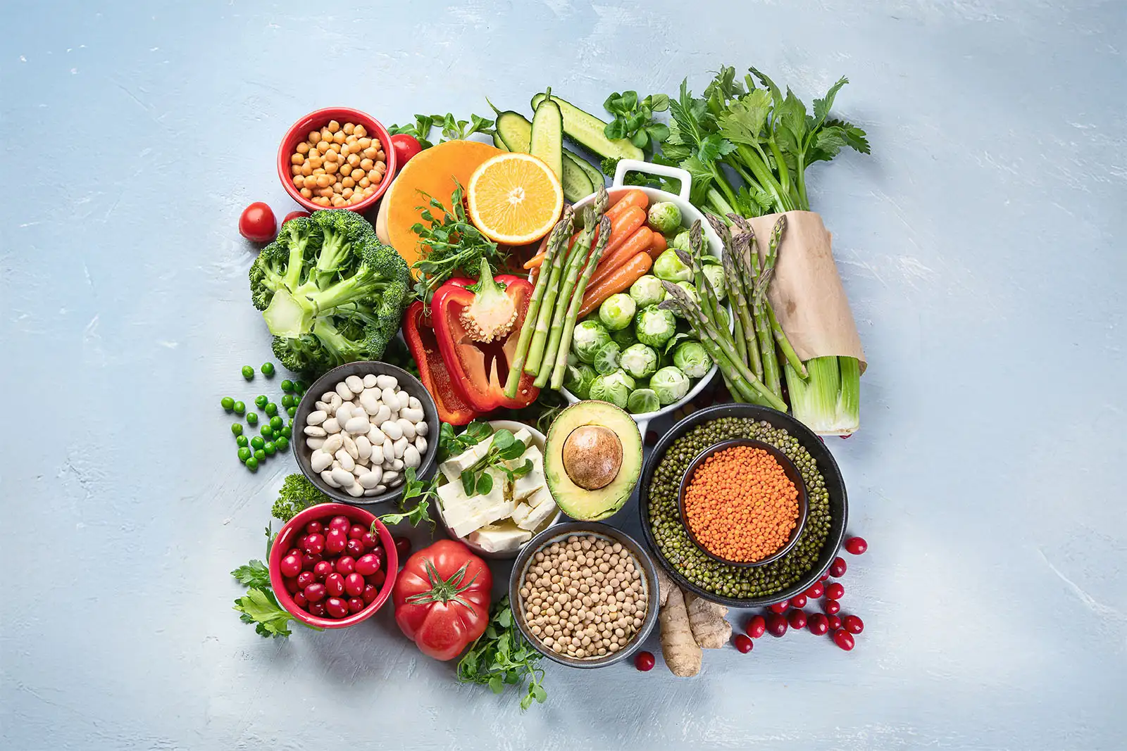 Assortiment de légumes et légumineuses en flatlay (avocat, asperges, pois chiches, lentilles) — recettes végétariennes