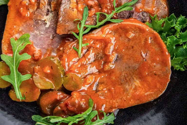 Tranches de langue de bœuf façon grand-mère nappées d'une sauce piquante à la tomate, aux cornichons et aux herbes fraîches.