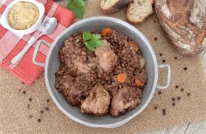 Marmite de petit salé aux lentilles vertes mijotées avec des carottes, accompagnée de pain de campagne et de moutarde à l'ancienne.