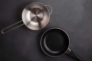 Comparaison entre une poêle antiadhésive et une poêle en inox pour illustrer le danger des PFAS et les alternatives de cuisson