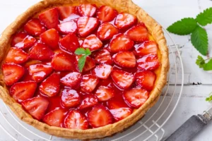 Tarte aux fraises sans crĂšme pĂątissiĂšre maison garnie de fraises fraĂźches et dâun nappage brillant.