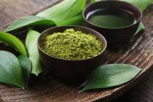 Poudre de thé matcha vert dans un bol avec une tasse de thé, pour illustrer les bienfaits du matcha