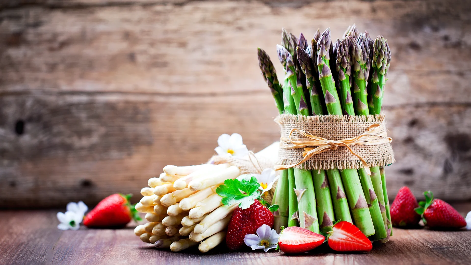 Botte d’asperges vertes avec asperges blanches et fraises fraîches, symboles des recettes de printemps