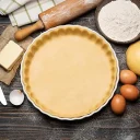 Pâte à tarte crue avec ingrédients de base — farine, beurre et œufs, pour pâtes et fonds maison